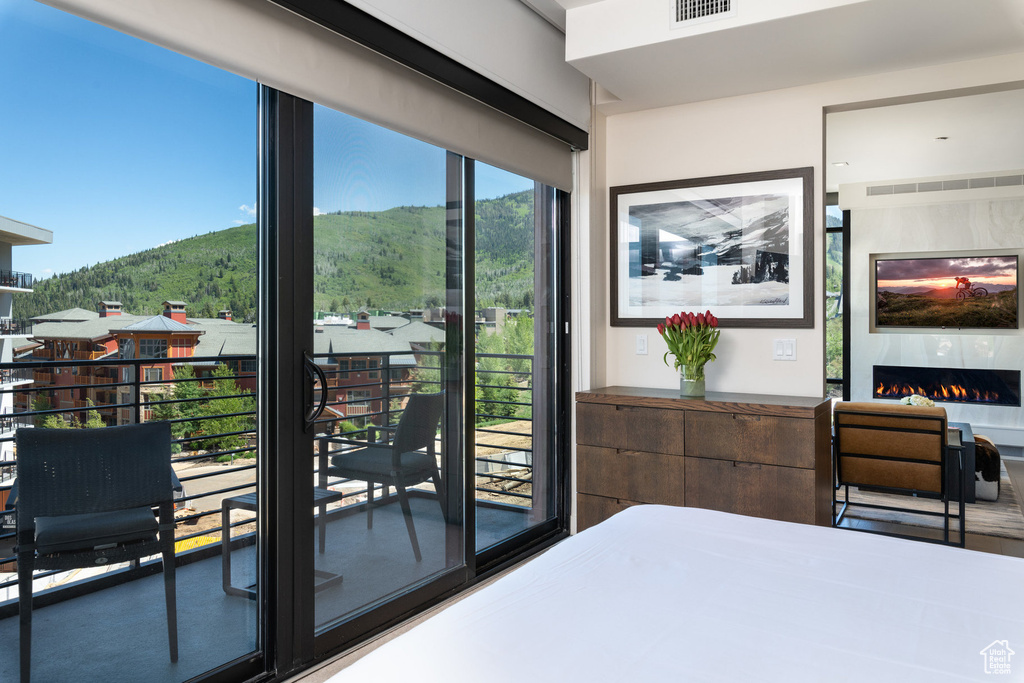 Bedroom with a mountain view and a warm lit fireplace