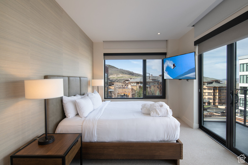 Bedroom with access to exterior, carpet, and multiple windows