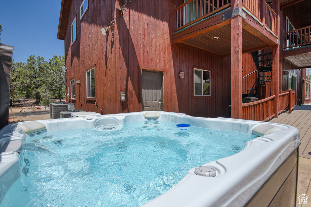 View of pool featuring a hot tub and a wooden deck