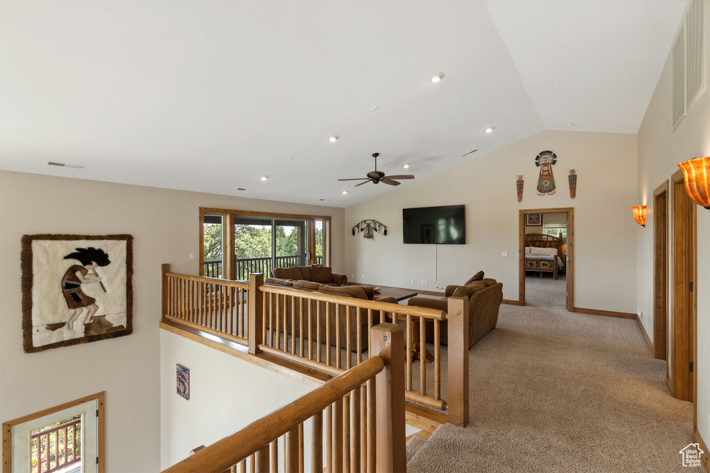 Hallway featuring an upstairs landing, lofted ceiling, light colored carpet, and recessed lighting