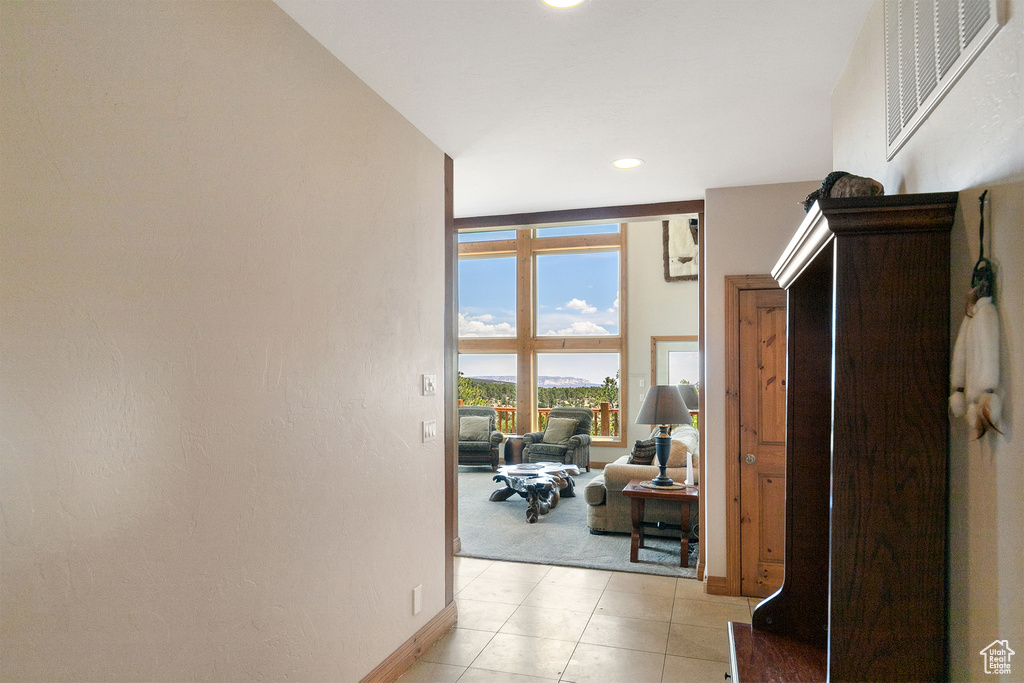 Hallway featuring light colored carpet, recessed lighting, and light tile patterned flooring