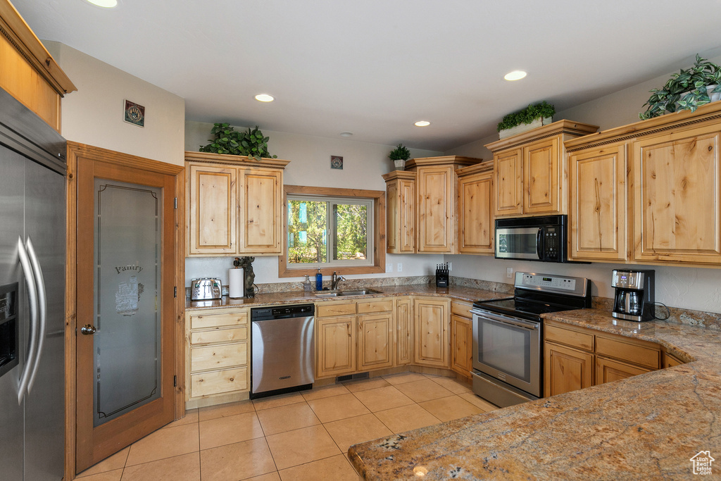 Kitchen with stainless steel appliances, light tile patterned floors, and recessed lighting