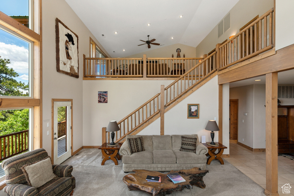 Tiled living room with high vaulted ceiling, ceiling fan, recessed lighting, and stairway