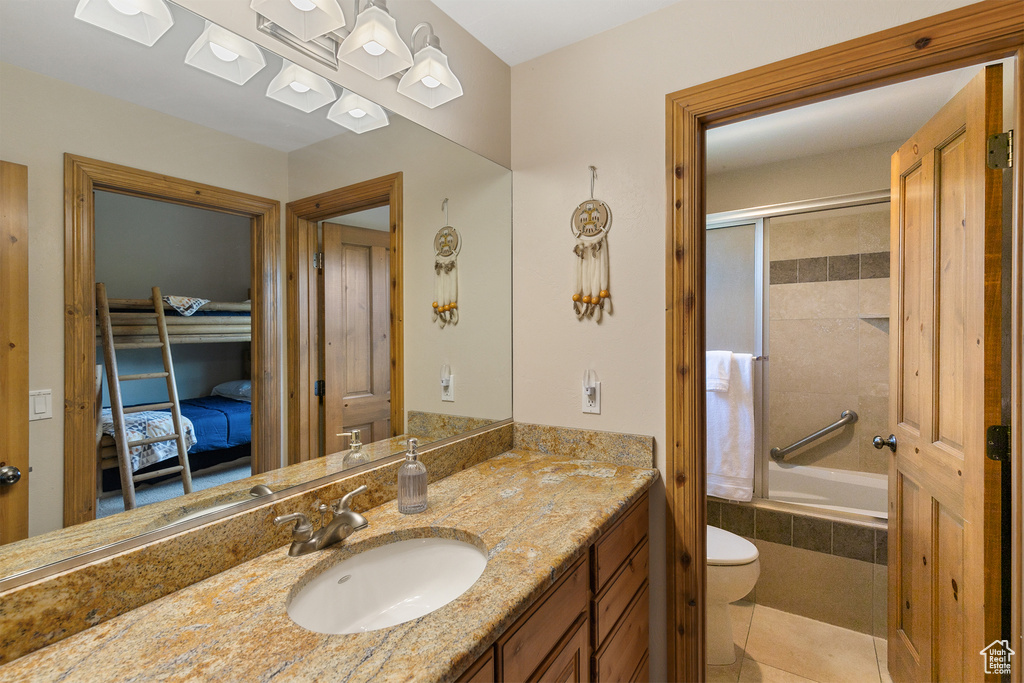 Bathroom with vanity, tiled shower / bath combo, and tile patterned flooring