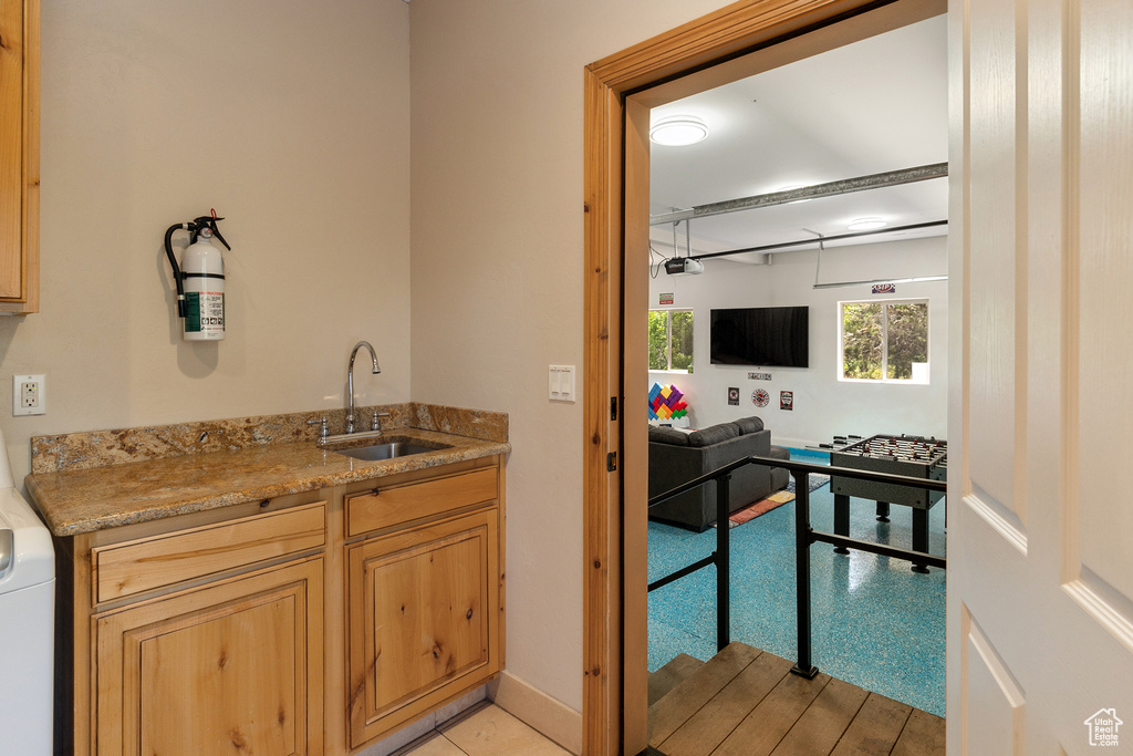 Kitchen featuring light wood-type flooring and light stone countertops