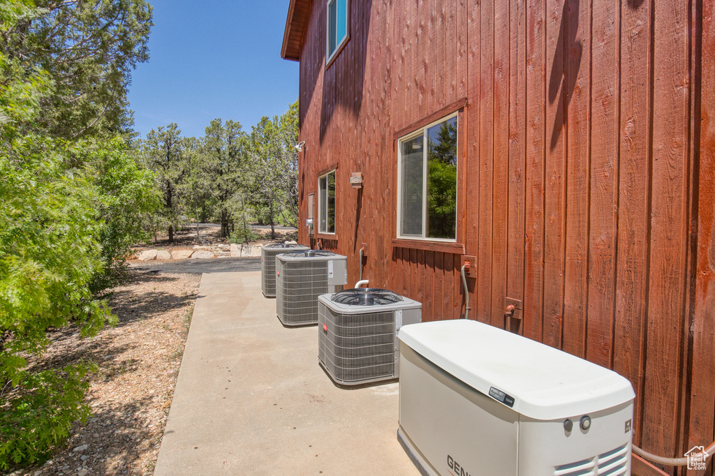 View of side of property featuring a central air condition unit and a patio