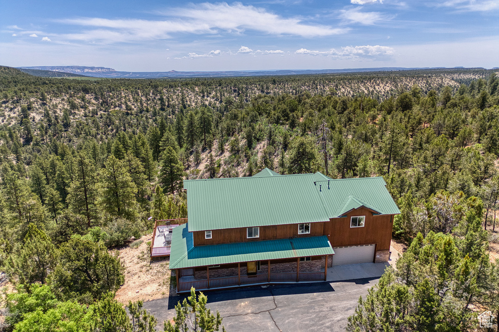 Aerial view of property and surrounding area with a forest
