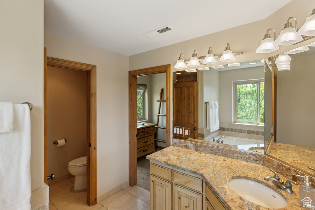 Bathroom featuring a garden tub, tile patterned floors, and vanity