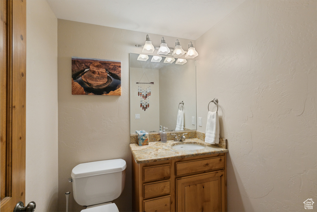 Half bathroom with vanity and toilet