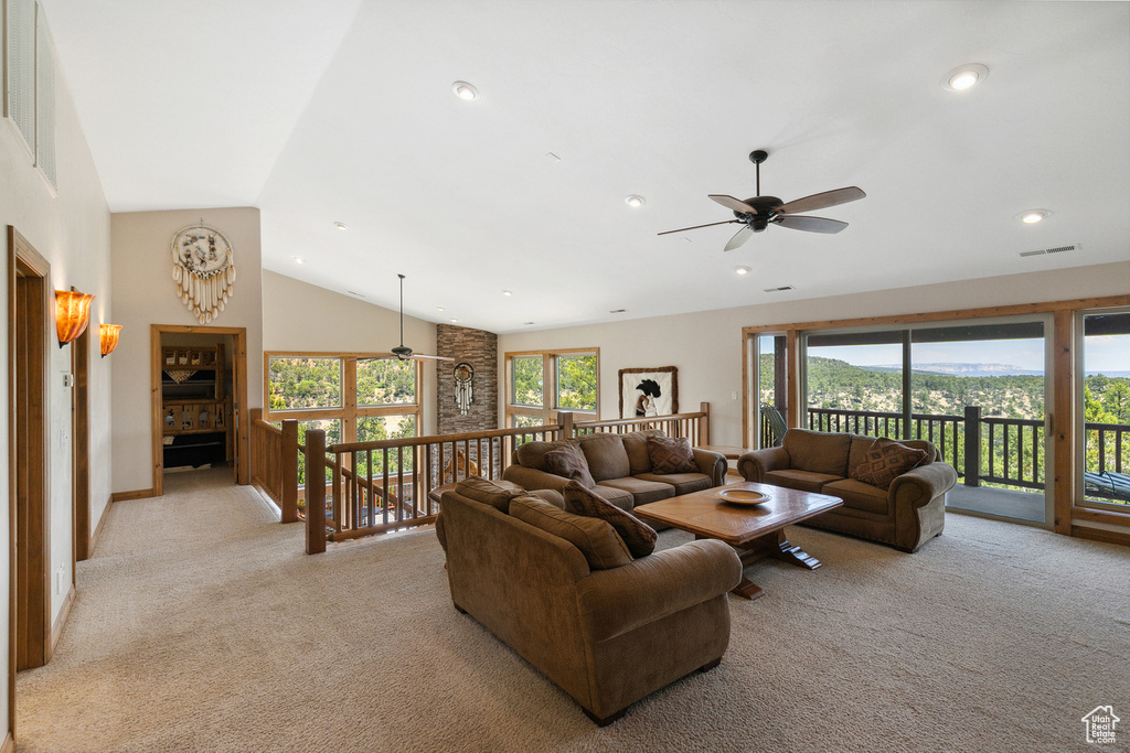 Living area with ceiling fan, light colored carpet, recessed lighting, and high vaulted ceiling
