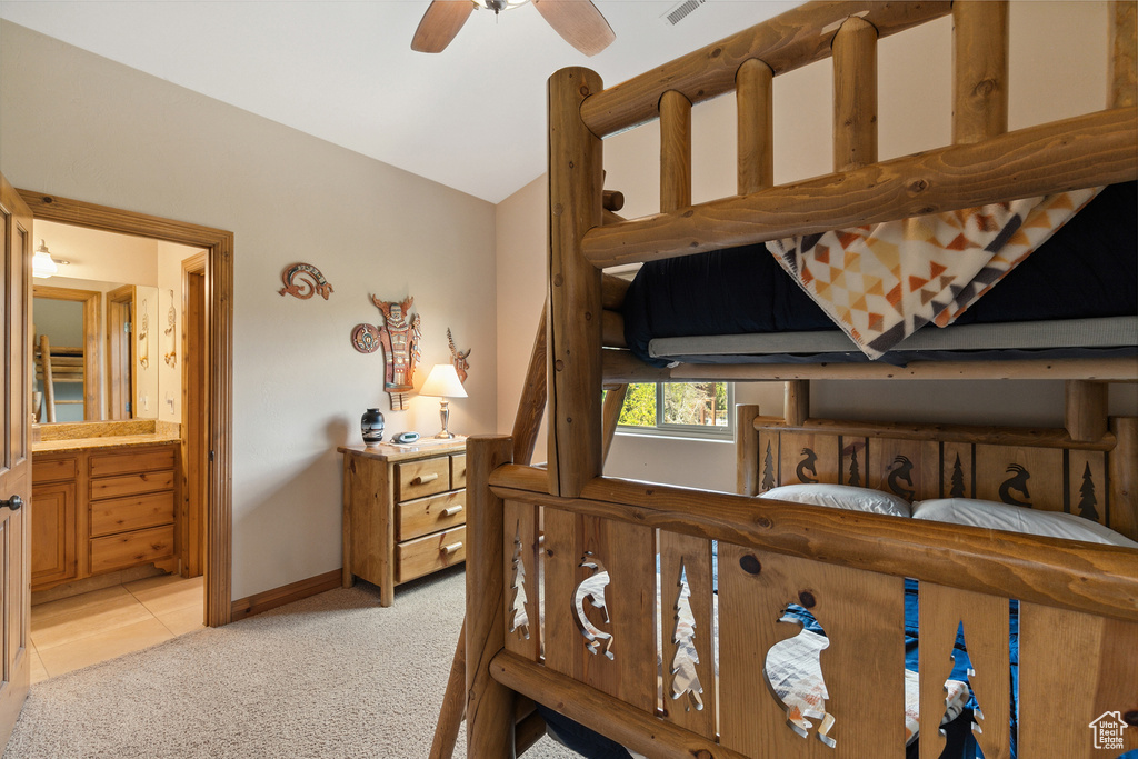 Bedroom with light carpet, vaulted ceiling, and connected bathroom