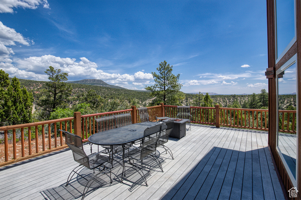 Wooden terrace featuring outdoor dining area and a mountain view