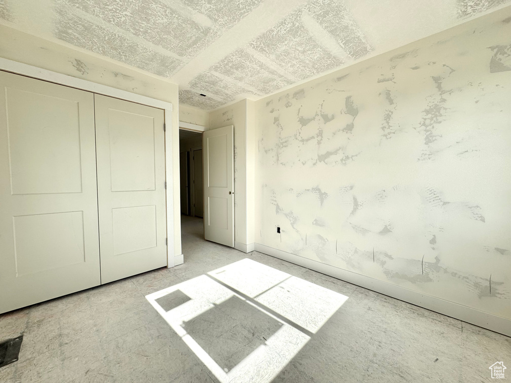 Unfurnished bedroom with a closet and baseboards