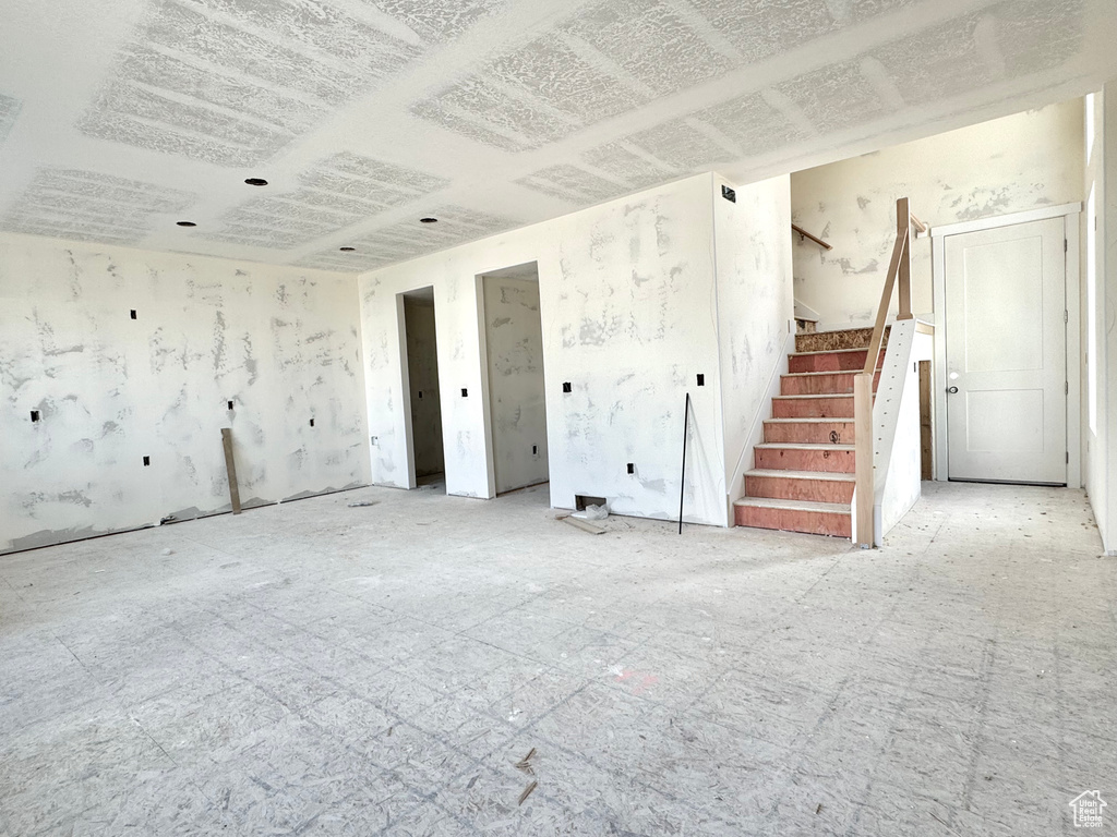 Unfurnished living room with stairway