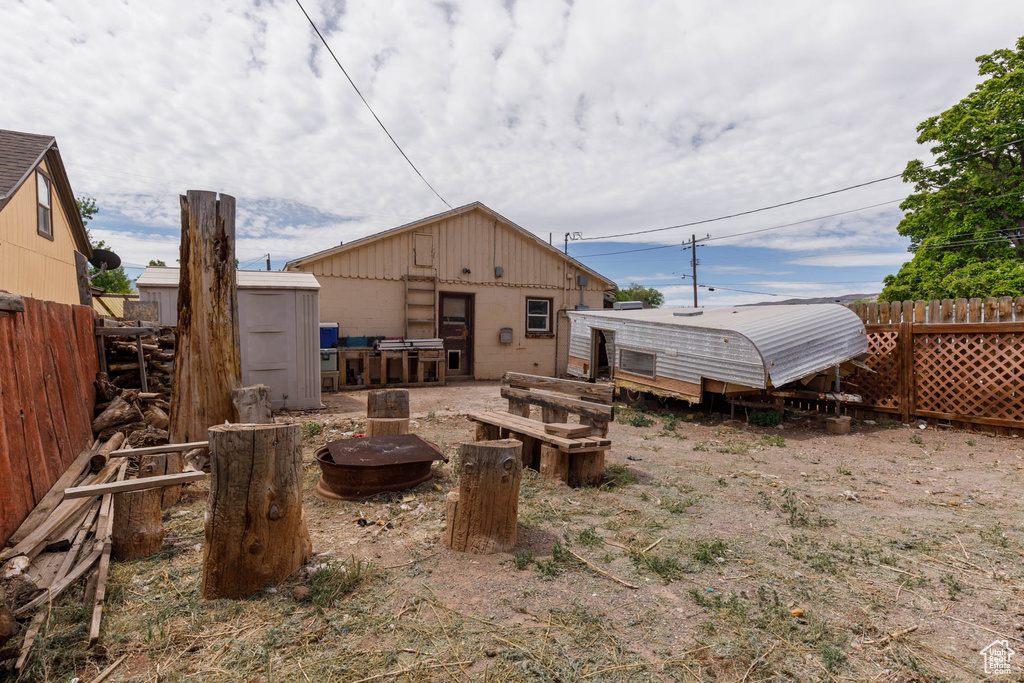 Rear view of property featuring a storage shed