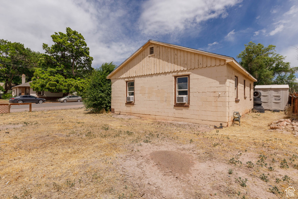 View of home's exterior with cooling unit and concrete block siding