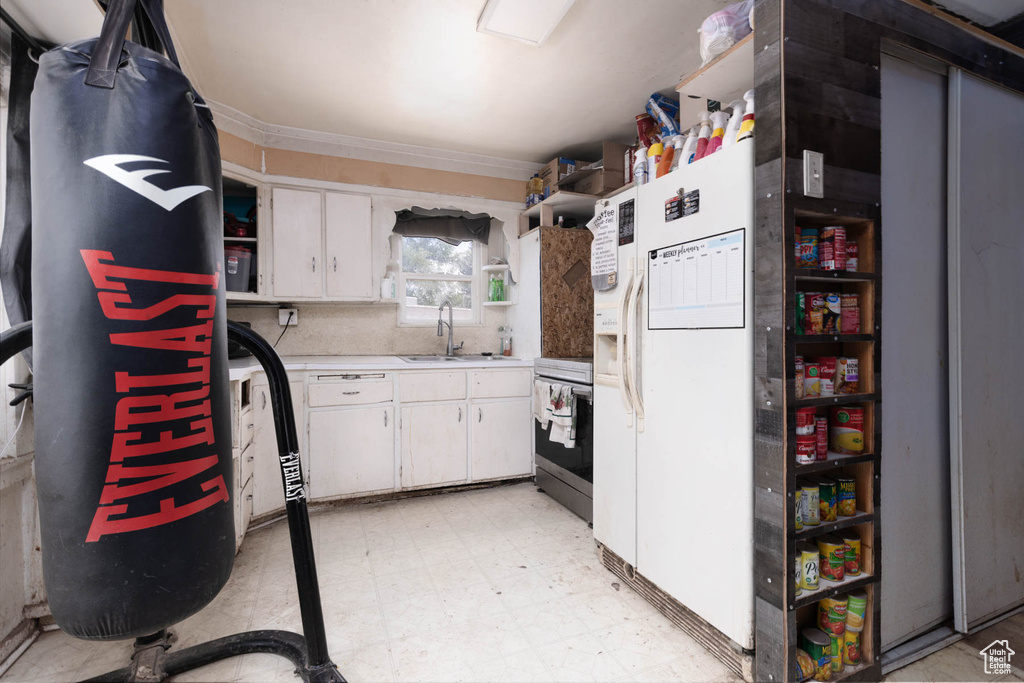 Kitchen with refrigerator, stainless steel range oven, open shelves, and light floors