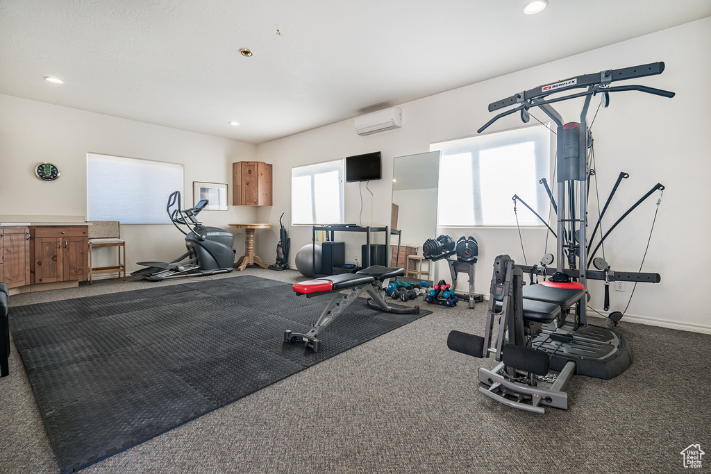 Exercise area featuring a wall mounted AC, recessed lighting, and carpet flooring
