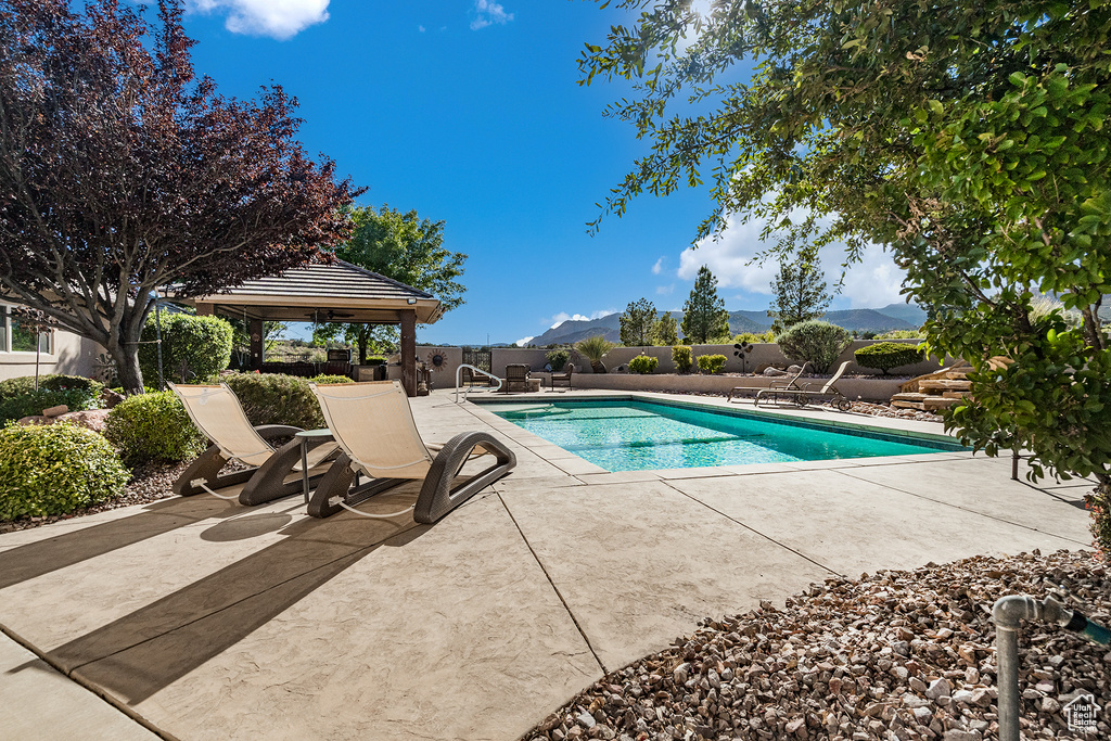 View of swimming pool with a gazebo, a patio area, and a mountain view