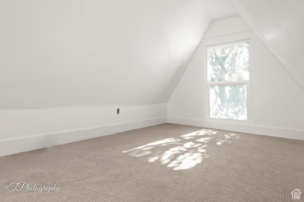 Additional living space featuring baseboards, carpet flooring, and vaulted ceiling