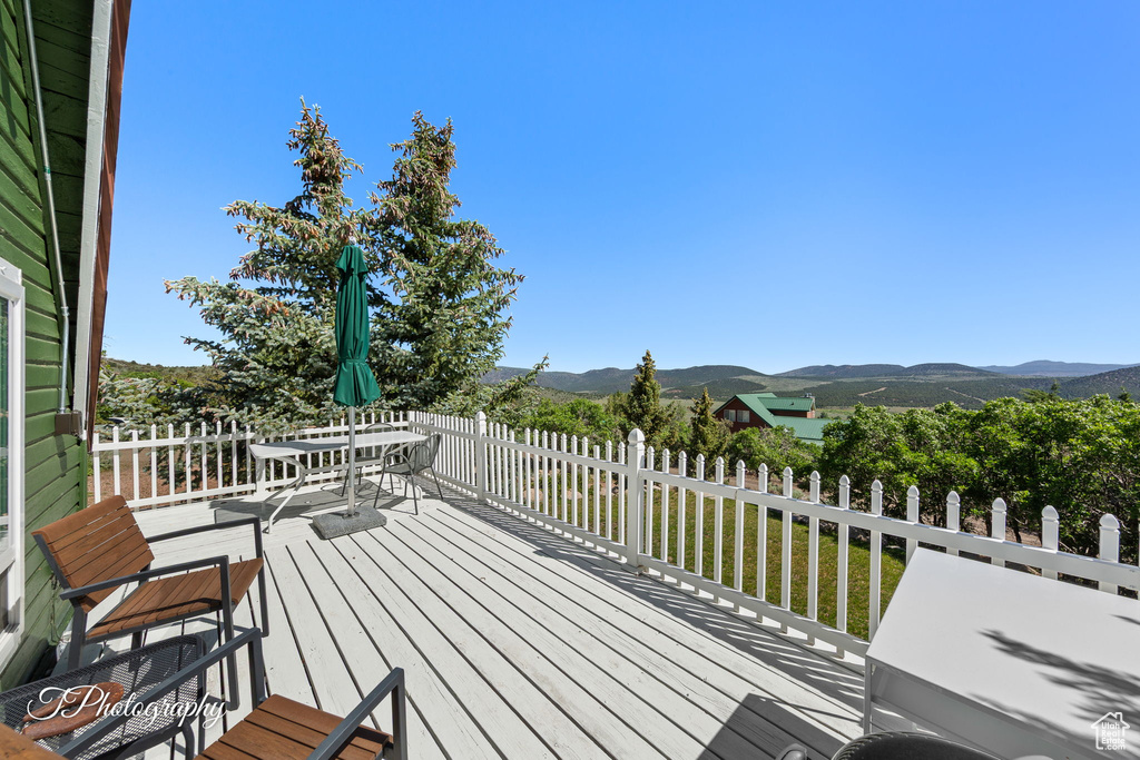 Wooden deck with a mountain view and outdoor dining space