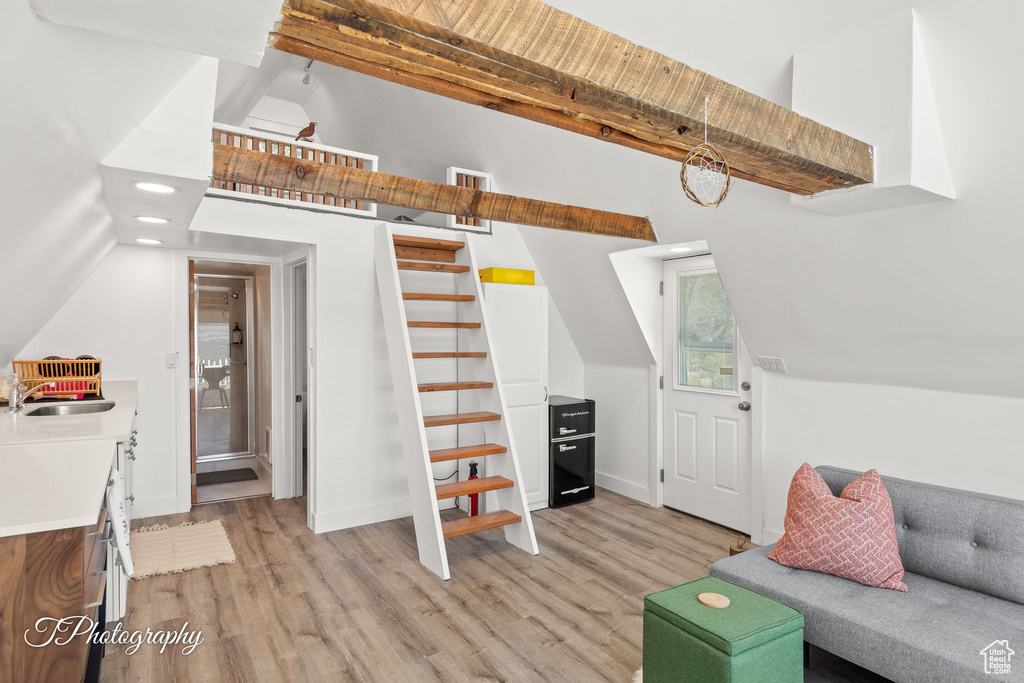 Living area with light wood-style flooring, stairway, and recessed lighting