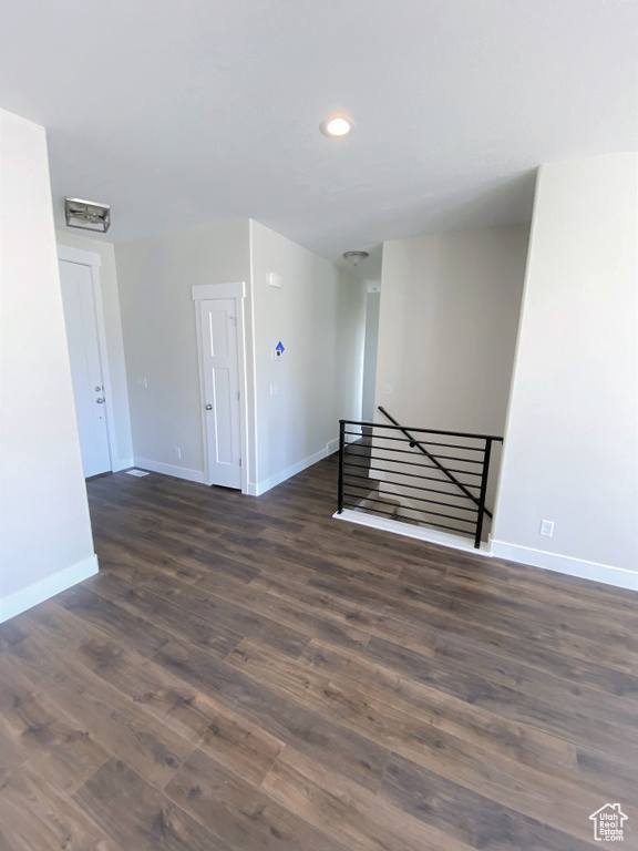 Empty room with dark wood finished floors and recessed lighting
