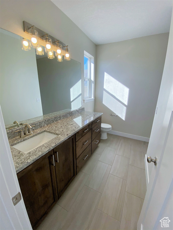 Bathroom featuring double vanity and toilet