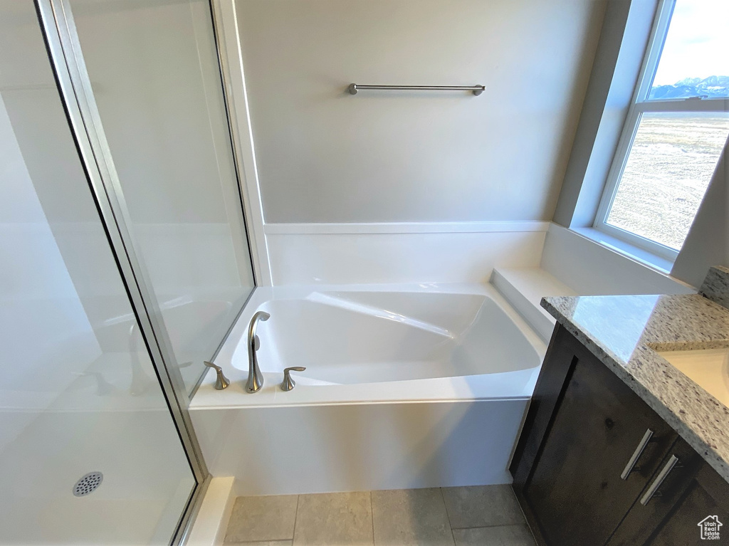 Full bath featuring vanity, a bath, and a stall shower