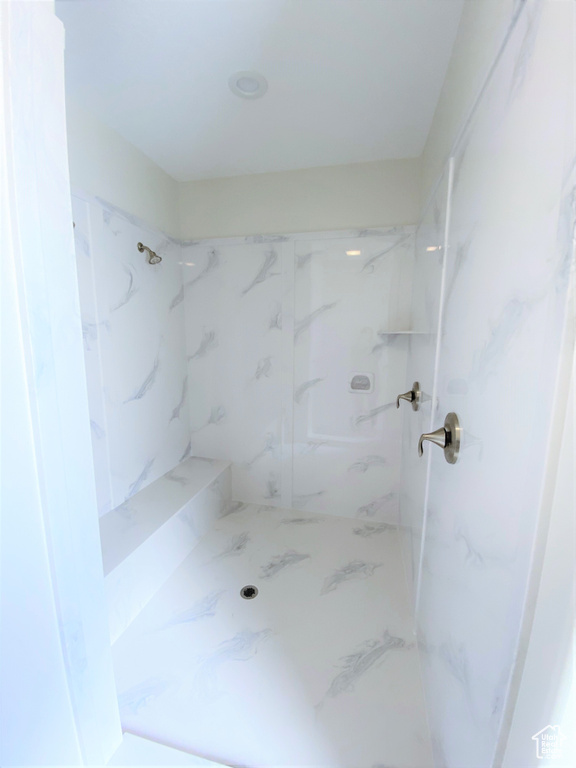Full bathroom with a marble finish shower