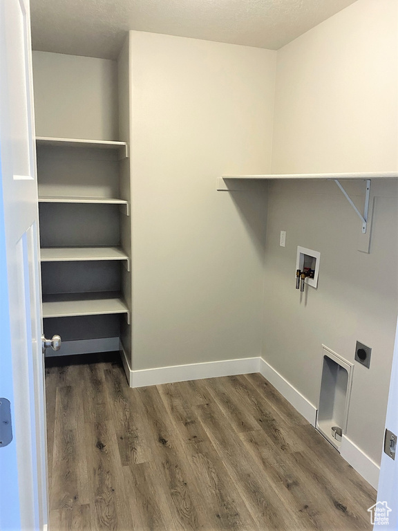 Washroom with electric dryer hookup, wood finished floors, and washer hookup