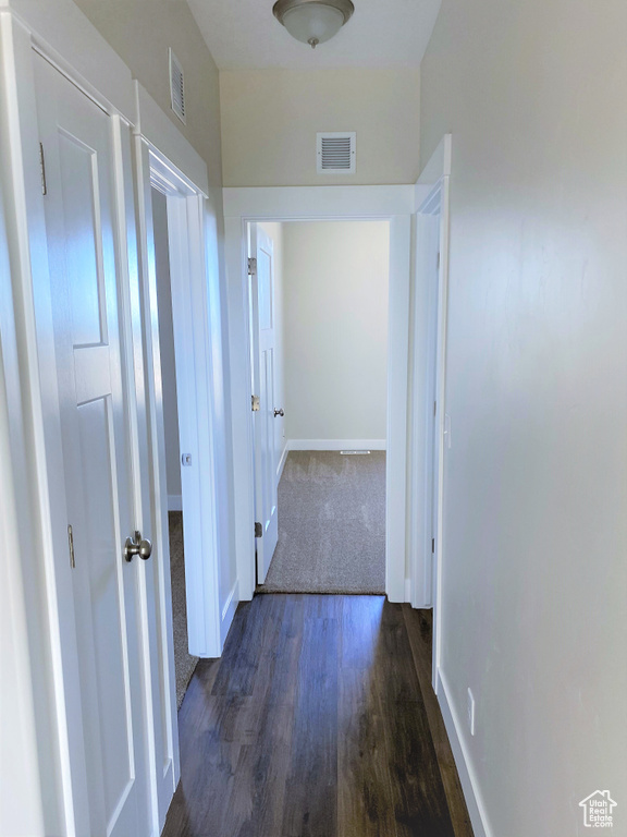 Corridor featuring dark wood-style floors and baseboards