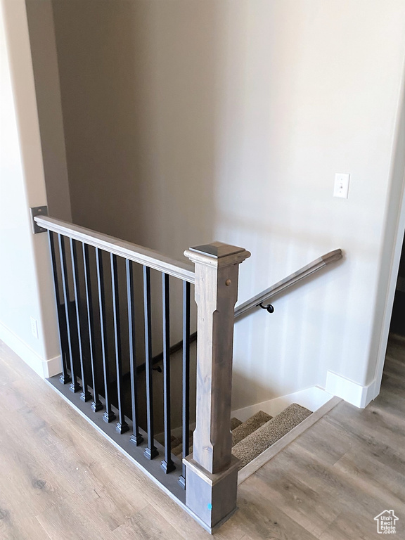 Staircase featuring wood finished floors