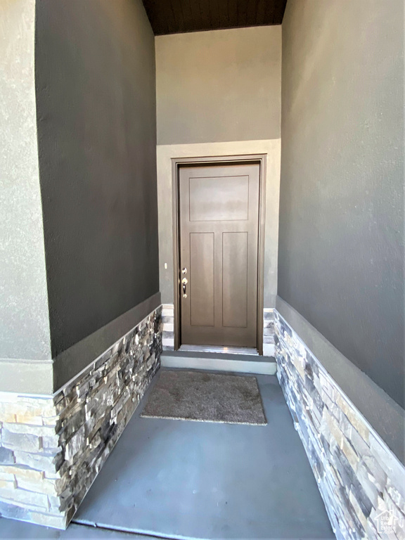 Doorway to property with stucco siding and stone siding