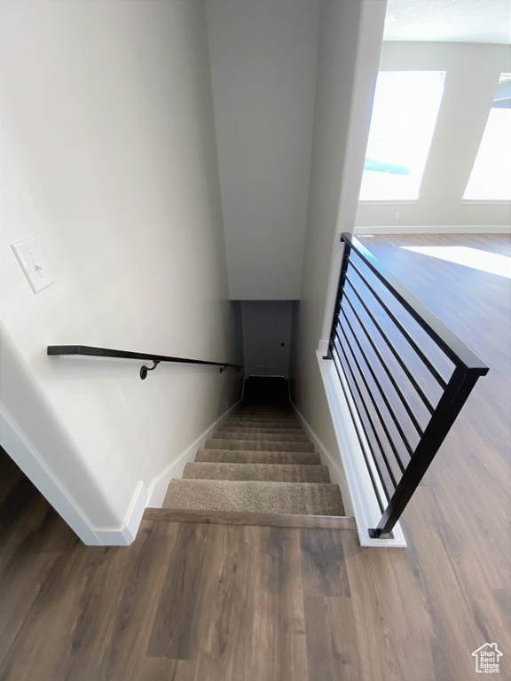Stairs featuring wood finished floors