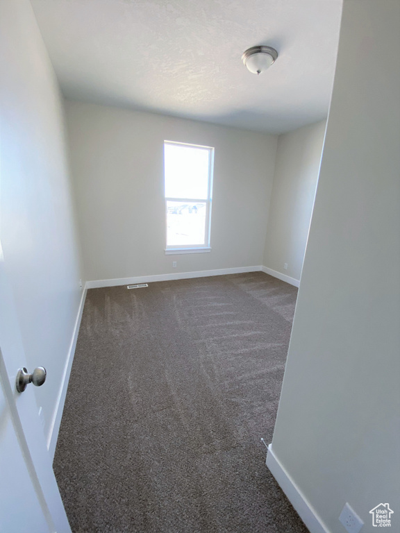 Carpeted spare room with baseboards