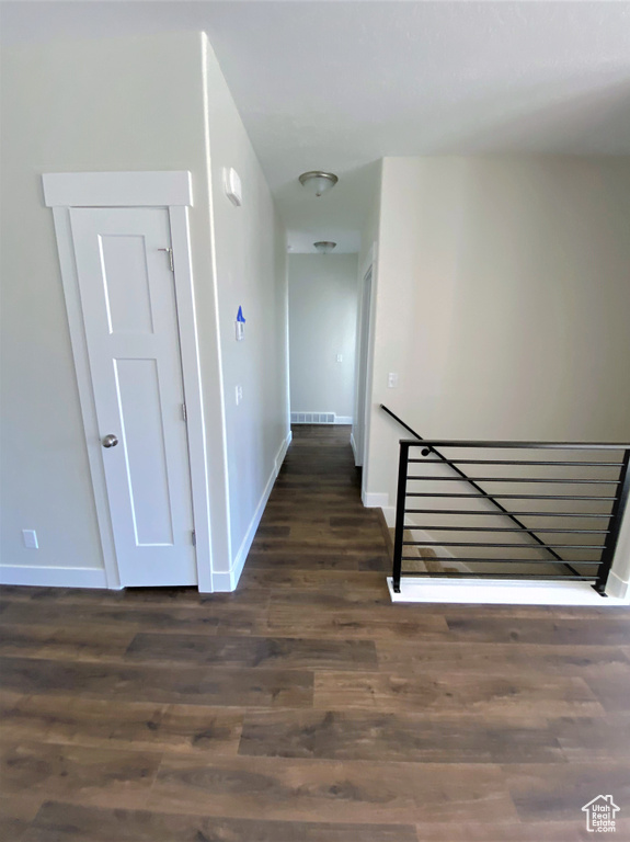 Hall featuring an upstairs landing and dark wood-style floors