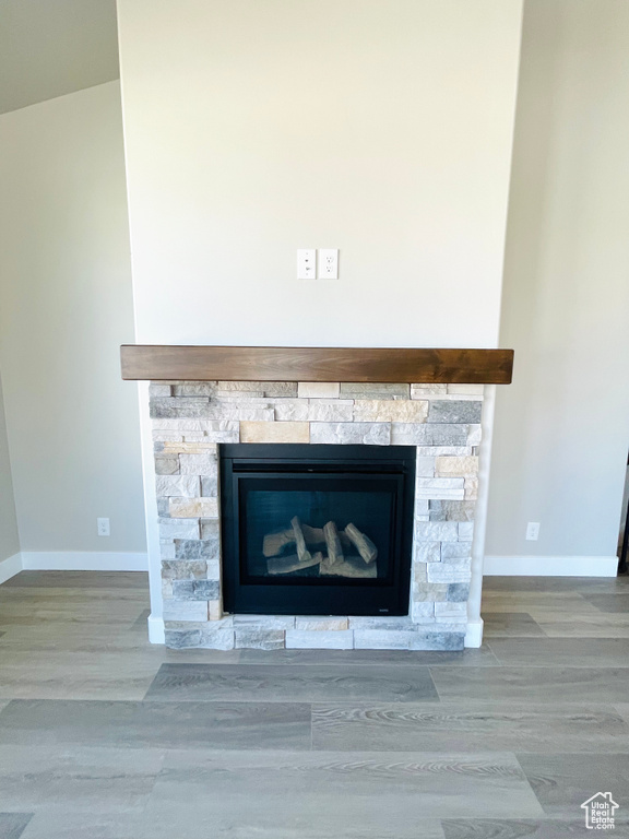 Detailed view of a fireplace and wood finished floors