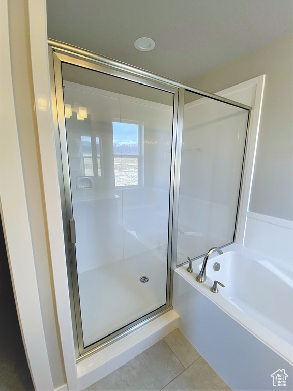 Bathroom with a shower stall, a bath, and tile patterned floors