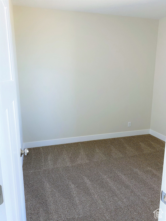 Empty room featuring carpet floors and baseboards