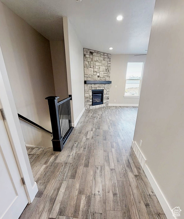 Unfurnished living room with wood finished floors, a fireplace, and recessed lighting