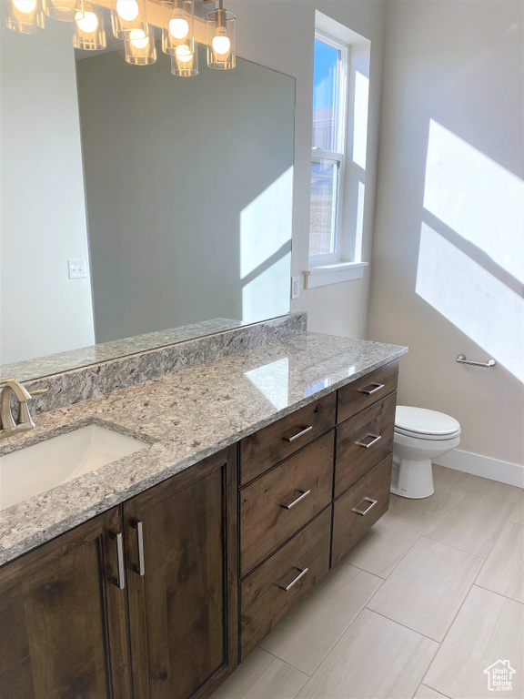 Full bathroom with double vanity, a chandelier, and tile patterned flooring