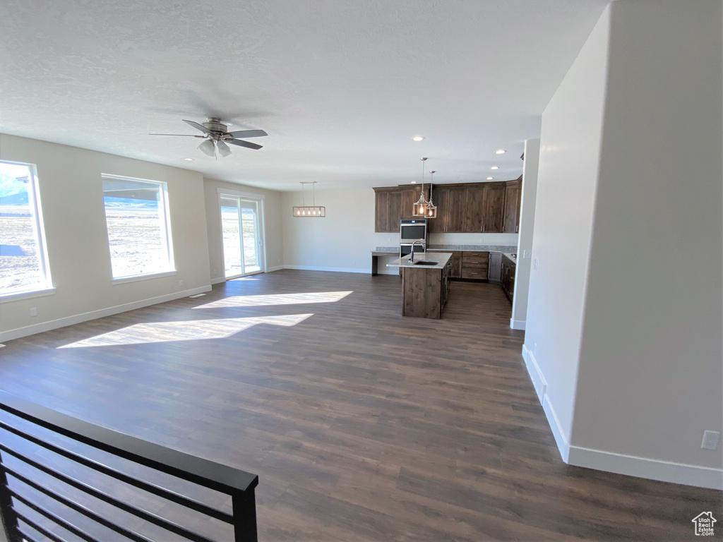 Unfurnished living room with dark wood-style flooring, recessed lighting, and a ceiling fan