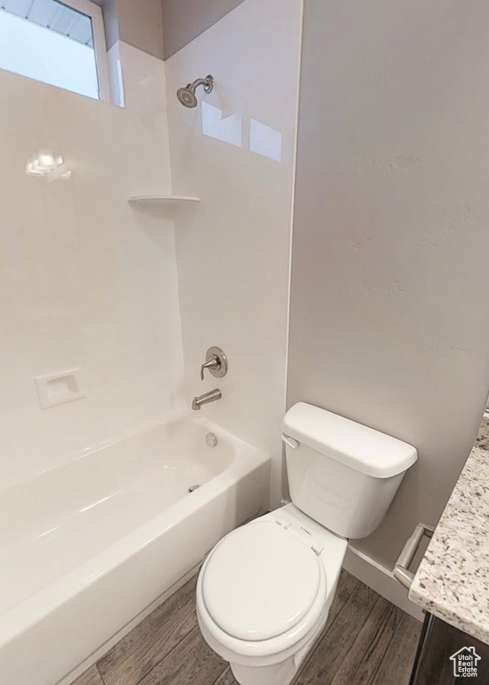 Bathroom featuring wood finished floors, vanity, and tub / shower combination