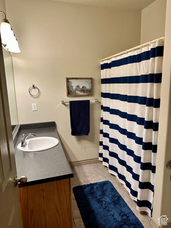Bathroom with vanity, tile patterned flooring, and a shower with curtain