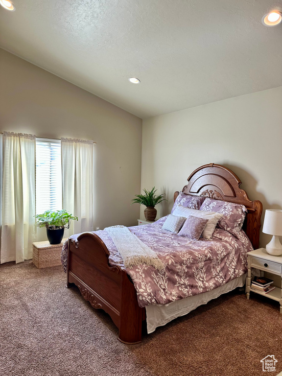 Carpeted bedroom with vaulted ceiling and recessed lighting