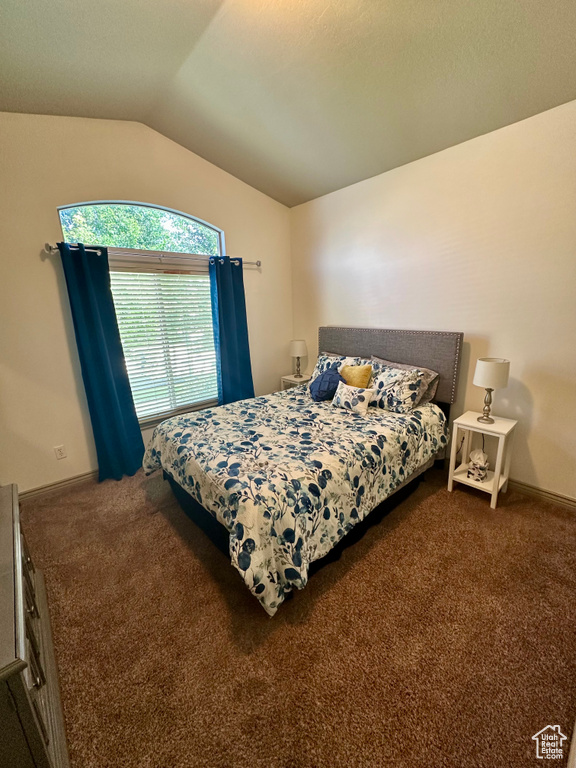 Bedroom with vaulted ceiling and carpet floors