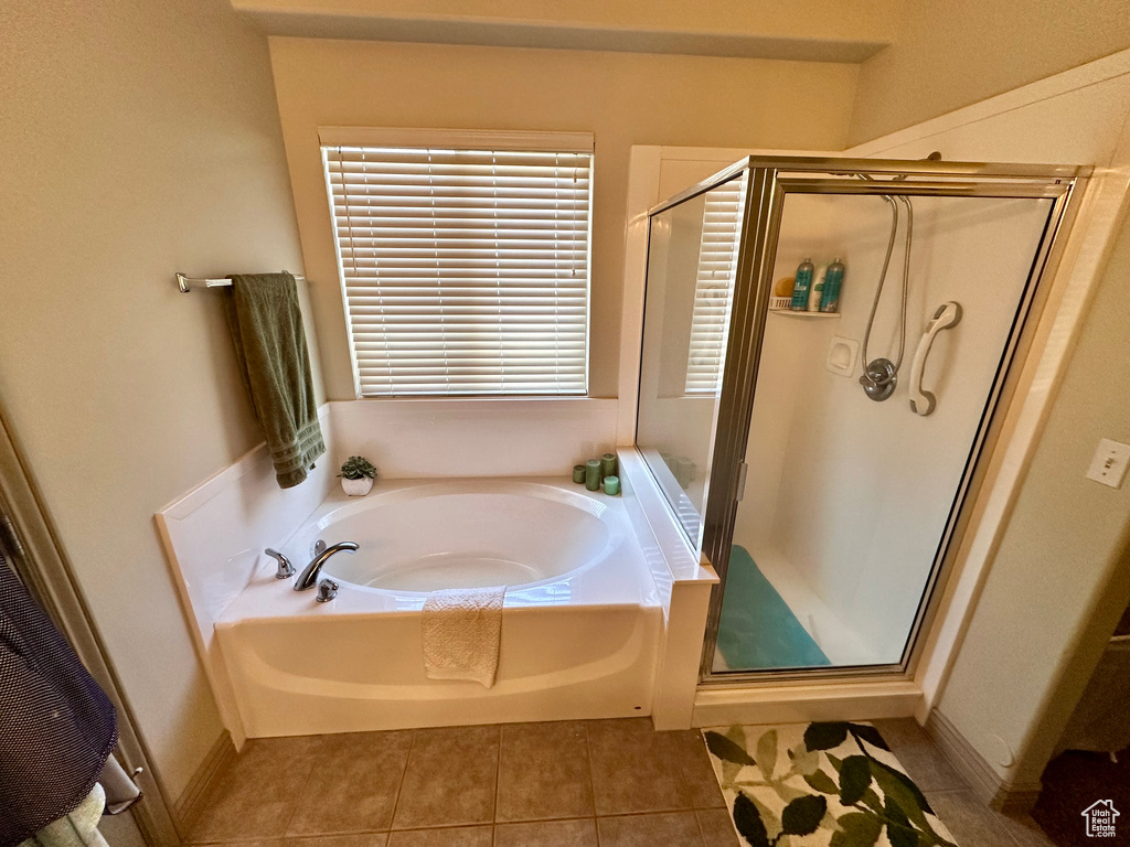 Bathroom featuring a bath, a shower stall, and tile patterned flooring
