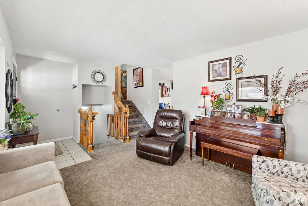 Living area featuring stairway and carpet flooring