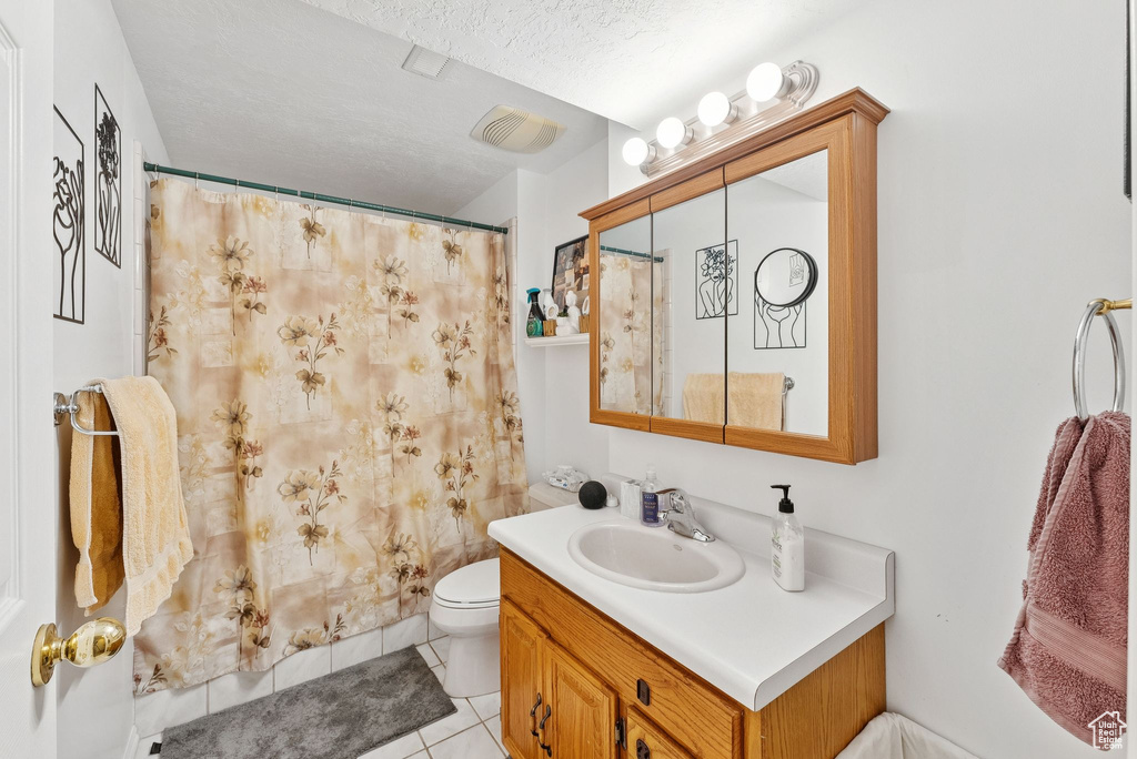 Full bath with vanity, tile patterned flooring, a shower with curtain, and a textured ceiling